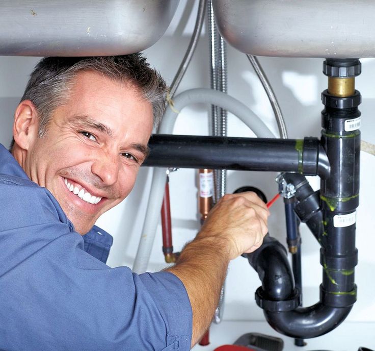 Plumber working on pipes